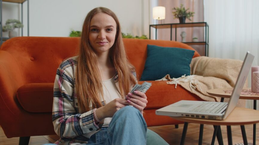 Smiling woman counting money at home